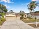 Charming single-story home with a well-manicured front lawn, mature trees, and a two-car garage at 815 Sandy Trail Pl, Brandon, FL 33511