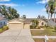 Charming single-story home with a well-manicured front lawn, mature trees, and a two-car garage at 815 Sandy Trail Pl, Brandon, FL 33511