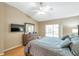 Comfortable primary bedroom with wood floors, flat screen television, and natural light from the window at 815 Sandy Trail Pl, Brandon, FL 33511