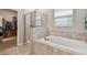 Bathroom with a separate shower, bathtub, and walk-in closet at 8772 Flourish Dr, Land O Lakes, FL 34637