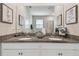 Bathroom featuring double vanity with granite counters, white cabinets, framed mirrors and decor at 8772 Flourish Dr, Land O Lakes, FL 34637