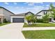 Charming single-story home features a well-manicured lawn, complemented by lush landscaping and a two-car garage at 8772 Flourish Dr, Land O Lakes, FL 34637