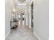Bright hallway featuring neutral paint, decorative table, and tile flooring at 8772 Flourish Dr, Land O Lakes, FL 34637
