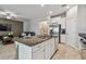 Kitchen island featuring granite countertop, stainless steel appliances and white cabinets at 8772 Flourish Dr, Land O Lakes, FL 34637