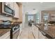 Well-lit kitchen with granite countertops, stainless steel appliances, and an open view to the dining area at 8772 Flourish Dr, Land O Lakes, FL 34637