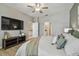 Bedroom featuring a ceiling fan, a large television, and two doorways at 8772 Flourish Dr, Land O Lakes, FL 34637