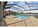 Screened in-ground pool with patio, lake view, and outdoor seating at 8772 Flourish Dr, Land O Lakes, FL 34637