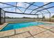 In-ground pool with screened enclosure, patio, and lake view with outdoor seating at 8772 Flourish Dr, Land O Lakes, FL 34637