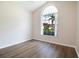 Empty bedroom featuring a large arched window, wood floors, and neutral walls for versatile decorating options at 8812 Beeler Dr, Tampa, FL 33626