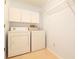 Well-lit laundry room featuring white appliances and cabinet storage above at 8812 Beeler Dr, Tampa, FL 33626