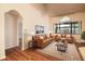Living room with wood floors, ceiling fan, and windows, virtually staged with sofas and decor at 8812 Beeler Dr, Tampa, FL 33626