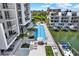 A view of a long swimming pool with lounge seating and palm trees between waterfront buildings at 920 N Osceola Ave # 301, Clearwater, FL 33755