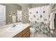 Bathroom with a neutral color palette featuring a vanity, toilet, and shower with patterned curtain at 10035 New Parke Rd, Tampa, FL 33626