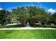 Entrance into a community lined with large beautiful trees and green space on a bright and sunny day at 10035 New Parke Rd, Tampa, FL 33626
