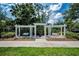 Beautiful community pergola with two benches and a trash can in front of a lush green landscape on a bright day at 10035 New Parke Rd, Tampa, FL 33626