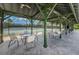 Covered patio with seating offers a relaxing spot overlooking the community tennis courts at 10035 New Parke Rd, Tampa, FL 33626