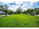 Expansive green space with lush grass, mature trees, and a central pergola creating a park-like community atmosphere at 10035 New Parke Rd, Tampa, FL 33626