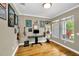 Bright home office featuring hardwood floors, a large window, and musical instruments at 10035 New Parke Rd, Tampa, FL 33626