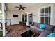 Covered brick patio with comfortable seating, a ceiling fan, and a mounted television for outdoor enjoyment at 10035 New Parke Rd, Tampa, FL 33626