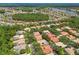 A broad aerial shot displays a neighborhood with mature trees, lakes, and homes, offering a peaceful and picturesque living environment at 10229 Waterside Oaks Dr, Tampa, FL 33647