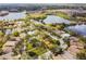 A scenic aerial view of a neighborhood, complete with a lake, lush trees, and recreational facilities at 10229 Waterside Oaks Dr, Tampa, FL 33647