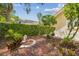 A serene backyard features mature trees, lush plantings, and a decorative statue, creating a private and tranquil outdoor space at 10229 Waterside Oaks Dr, Tampa, FL 33647