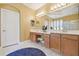 Bright bathroom featuring double sinks, vanity, decorative mirror and stool, with tile flooring and a white door at 10229 Waterside Oaks Dr, Tampa, FL 33647