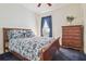 Comfortable bedroom featuring a floral comforter, side table, and chest of drawers at 10229 Waterside Oaks Dr, Tampa, FL 33647