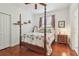 Bedroom featuring a four-poster bed with palm tree bedding, hardwood floors, and a side table at 10229 Waterside Oaks Dr, Tampa, FL 33647