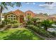 Charming home featuring mature landscaping, a clay tile roof, and a welcoming entrance at 10229 Waterside Oaks Dr, Tampa, FL 33647