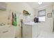 Functional laundry room with washer, dryer, utility sink, and ample shelving at 10229 Waterside Oaks Dr, Tampa, FL 33647