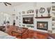 Comfortable living room featuring a fireplace, built-in shelves, hardwood floors, and ample natural light at 10229 Waterside Oaks Dr, Tampa, FL 33647