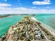 Picturesque aerial view of beachfront houses, a pristine sandy beach, and crystal blue water, all under a clear sky at 106 13Th Ave, St Pete Beach, FL 33706
