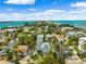 Beautiful aerial view of a waterfront community with lush greenery, beaches, and bridge in the distance at 106 13Th Ave, St Pete Beach, FL 33706