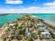 Gorgeous aerial view of an upscale neighborhood with beach access, a sandy beach, and shimmering blue water at 106 13Th Ave, St Pete Beach, FL 33706