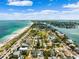 Expansive aerial view displaying a beachfront community, a sandy beach, and the expansive blue ocean under a sunny sky at 106 13Th Ave, St Pete Beach, FL 33706