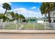 Charming single-story home with a white picket fence and lush lawn, surrounded by palm trees at 106 13Th Ave, St Pete Beach, FL 33706