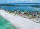 Aerial view of a coastal home boasting a stunning sandy beach and emerald waters at 1070 Eldorado Ave, Clearwater Beach, FL 33767