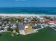 Aerial view of coastal community with tennis court, pool, and private beach at 1070 Eldorado Ave, Clearwater Beach, FL 33767