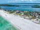 Stunning aerial view of beachfront homes along a pristine coastline with turquoise waters at 1070 Eldorado Ave, Clearwater Beach, FL 33767