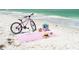 Beach picnic scene featuring a bicycle and beach accessories laid out on the sand at 1070 Eldorado Ave, Clearwater Beach, FL 33767
