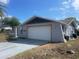 View of the two-car garage on a single-story home at 11010 Salt Tree Dr, Port Richey, FL 34668