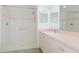 Bathroom with a large mirror, vanity, and stand-up shower with white tile and pink accent at 1142 Sweet Jasmine Dr, Trinity, FL 34655