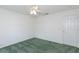 Bedroom features green carpets, a ceiling fan, and a white door at 1142 Sweet Jasmine Dr, Trinity, FL 34655