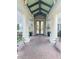 Welcoming entrance with decorative glass double doors and stately columns with benches at a senior living community at 1142 Sweet Jasmine Dr, Trinity, FL 34655