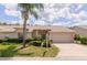 Charming single-story home featuring a well-manicured lawn and a two-car garage, and a large palm tree at 1142 Sweet Jasmine Dr, Trinity, FL 34655