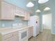 Bright kitchen with white appliances, tile floors, and stylish light fixture at 1142 Sweet Jasmine Dr, Trinity, FL 34655