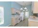Bright kitchen with white appliances, ample counter space, and stylish light fixtures at 1142 Sweet Jasmine Dr, Trinity, FL 34655