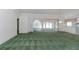 Large, bright living room with view to a sliding glass door and decorative green carpet at 1142 Sweet Jasmine Dr, Trinity, FL 34655