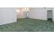 Spacious living room with neutral walls, large chandelier and green carpet at 1142 Sweet Jasmine Dr, Trinity, FL 34655